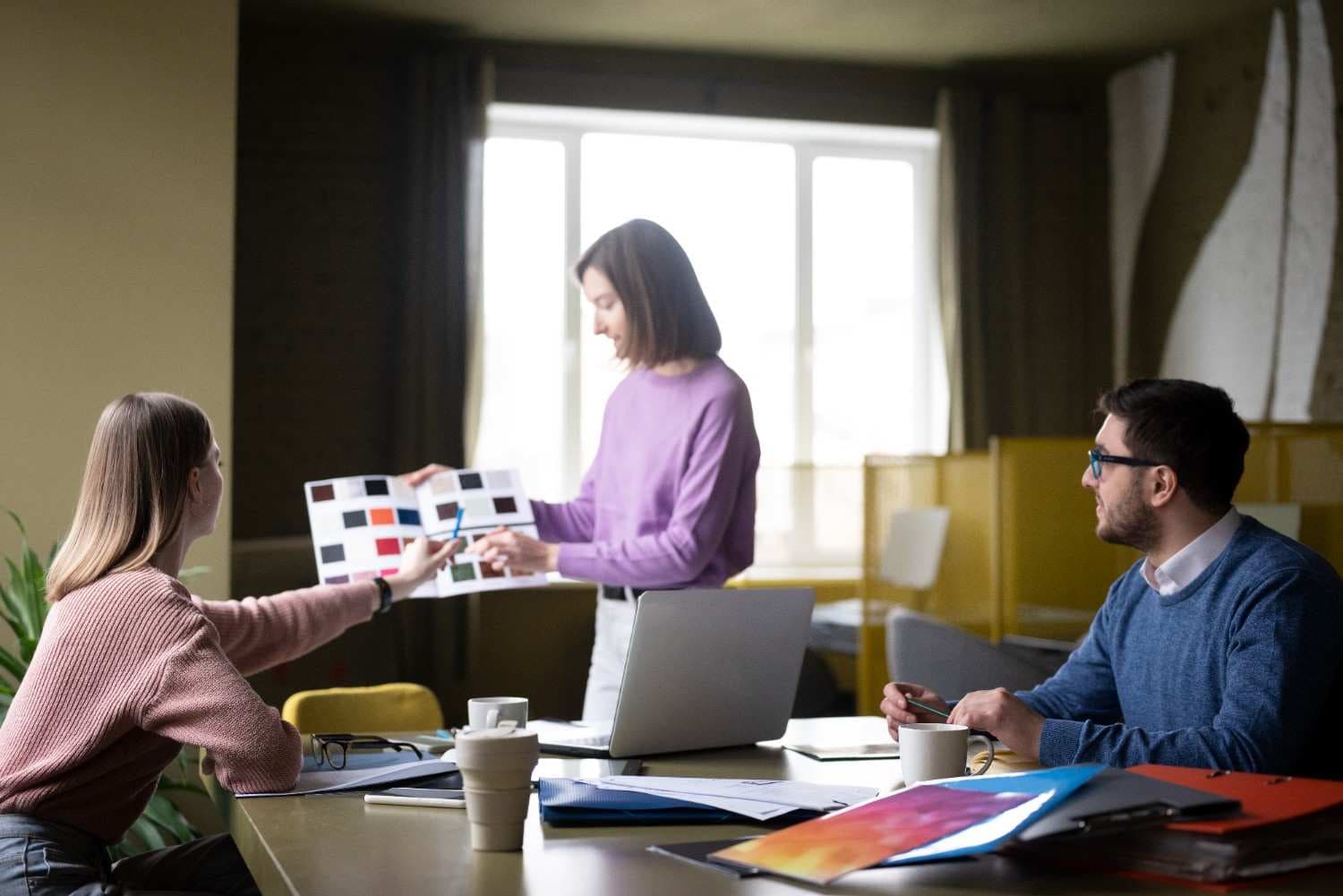 Professional team discussing financial decisions on laptop